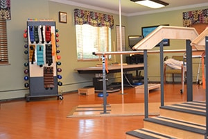 Rehabilitation gym with nicely organized equipment on shelving.