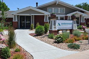 Amberwood entrance with sidewalk and plants beside the walkway.