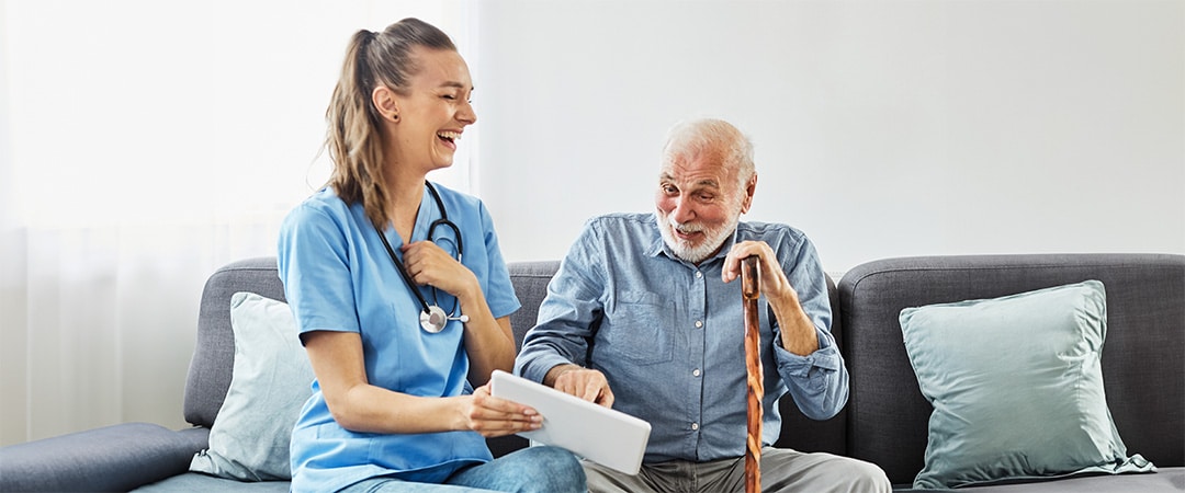 A nurse and a man laughing at a photo