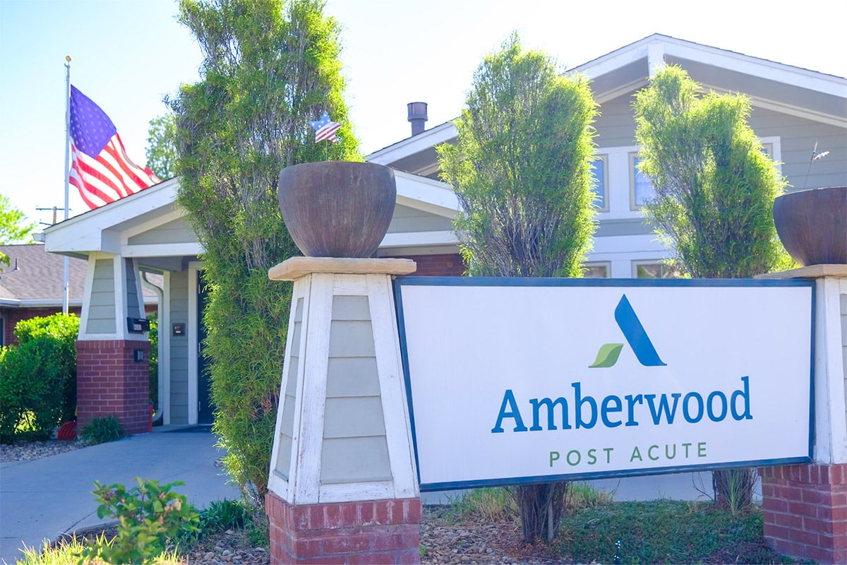 Front outdoor view of Amberwood Post Acute's sign and front porch