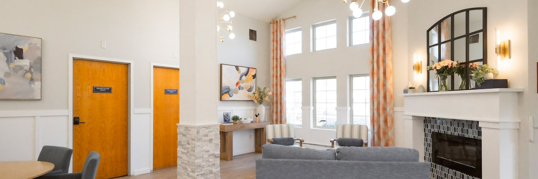 Common area with couch, fireplace, and floor-to-ceiling windows at Amberwood Post Acute