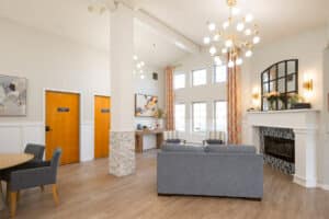 Common area with couch, fireplace, and floor-to-ceiling windows at Amberwood Post Acute