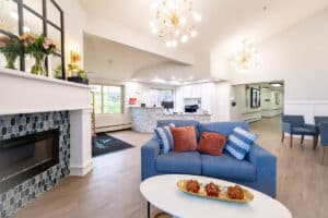 Common area with couch, front desk, and fireplace at Amberwood Post Acute