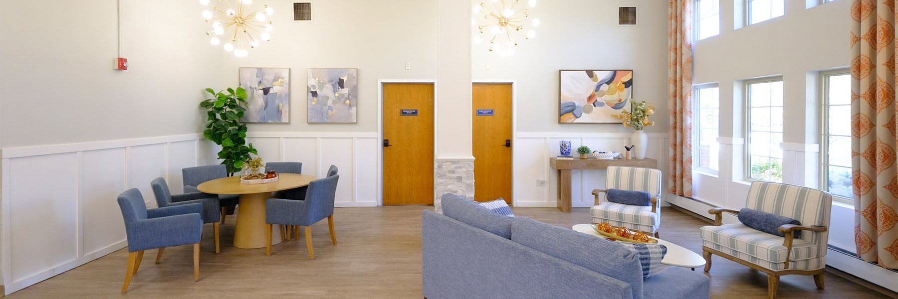 Common area with couch, two chairs, and dining set at Amberwood Post Acute