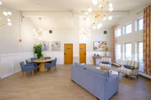 Common area with couch, two chairs, and dining set at Amberwood Post Acute